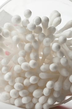 White cotton swabs in plastic container