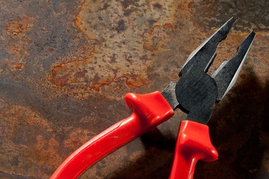 Pliers on the rusty plate