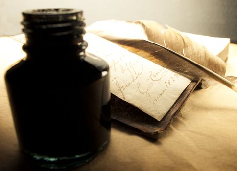 Old book with feather and inkpot 
