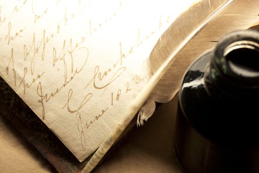 Old book with feather and inkpot 