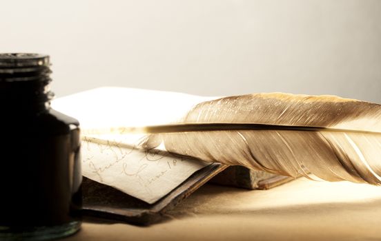 Old book with feather and inkpot 