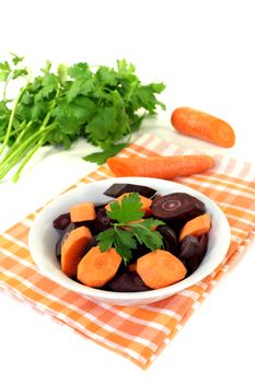 fresh orange and purple carrots on a light background