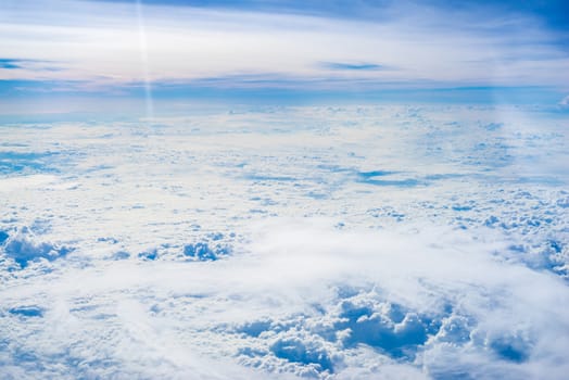 The View from the plane window above the cloud and blue sky