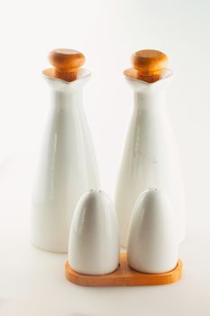 Salt, pepper, oil, vinegar containers over white