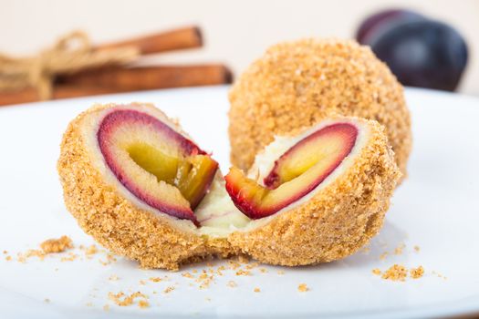 Close up of delicious sweet plum dumplings on white plate