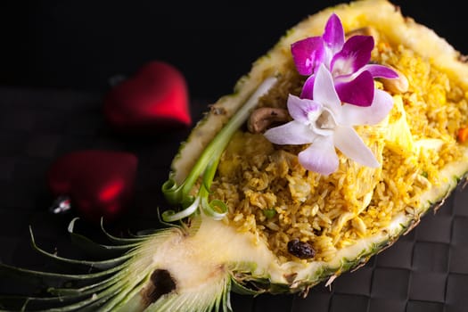 Freshly prepared pineapple fried rice served inside of a pineapple carved like a bowl.