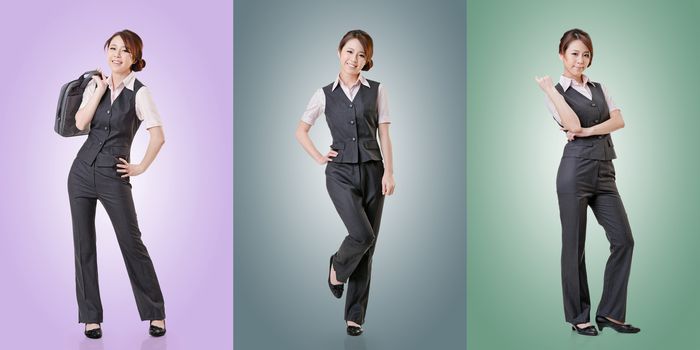 Asian business woman standing against studio background, full length portrait in a set.