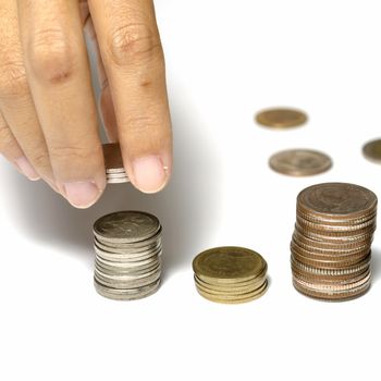 woman hand putting stack of coins on a white background