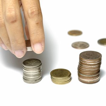 woman hand putting stack of coins on a white background
