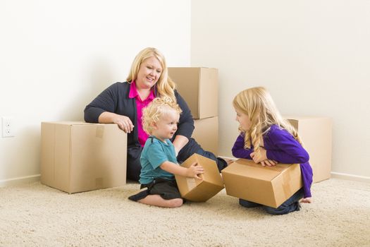 Happy Young Family in Empty Room With Moving Boxes.