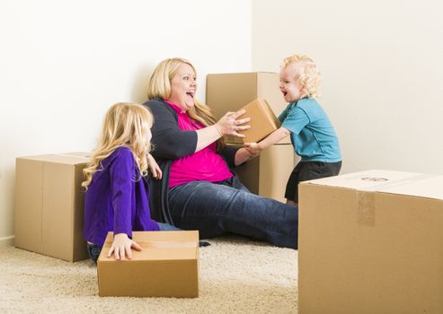 Playful Young Family In Empty Room Playing With Moving Boxes.