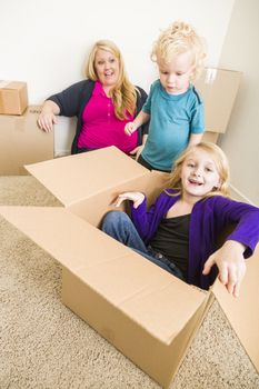 Playful Young Family In Empty Room Playing With Moving Boxes.