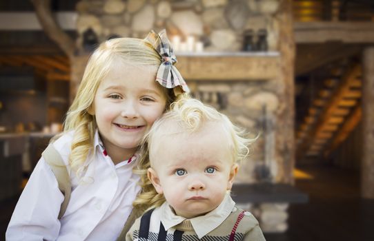 Cute Young Brother and Sister Pose In Rustic Cabin.