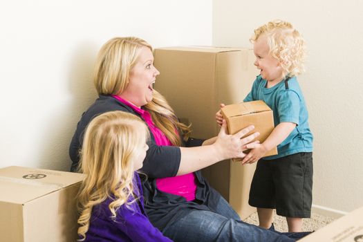 Playful Young Family In Empty Room Playing With Moving Boxes.