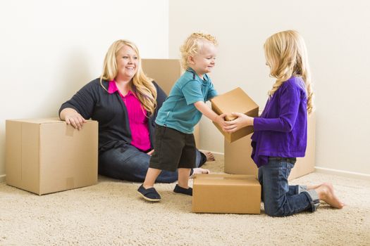 Happy Young Family in Empty Room With Moving Boxes.