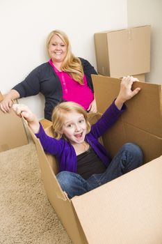 Playful Young Family In Empty Room Playing With Moving Boxes.