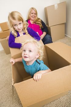 Playful Young Family In Empty Room Playing With Moving Boxes.