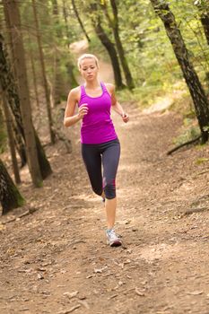 Pretty young girl runner in the forest.  Running woman. Female Runner Jogging during Outdoor Workout in a Nature. Beautiful fit Girl. Fitness model outdoors. Weight Loss. Healthy lifestyle. 