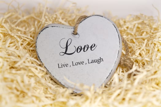 single wooden love heart in a love nest made of straw