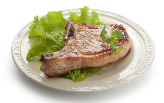 Fried pork cutlet with fresh green lettuce on the plate