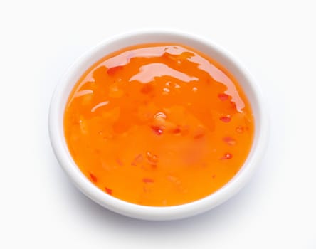 Orange sweet and sour sauce in the white bowl