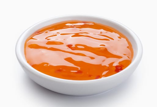 Orange sweet and sour sauce in the white bowl