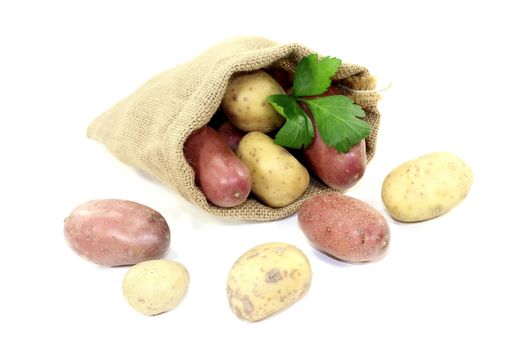 Potatoes in a sack on bright background