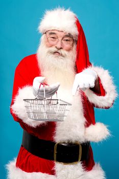Santa claus pointing and showing shopping basket