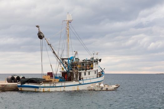 Old rusty fishing boat moored in the harbour.