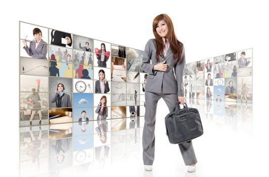Cheerful Asian business woman standing in front of TV screen wall.