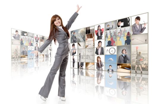 Cheerful Asian business woman standing in front of TV screen wall.