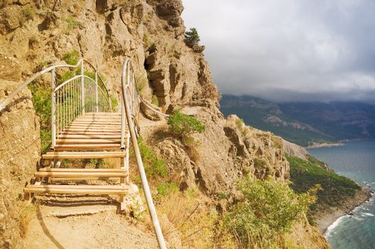 mountain trail with a bridge over the sea