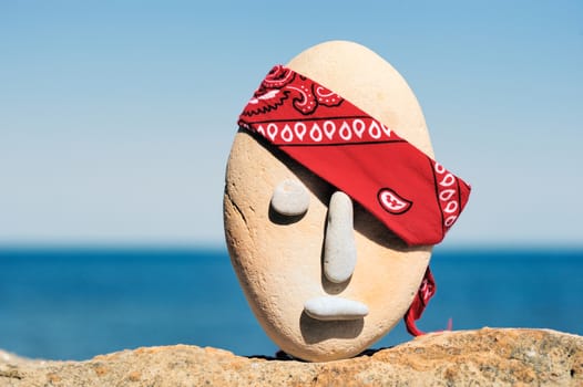 Symbol of stone head with a patterned red bandana