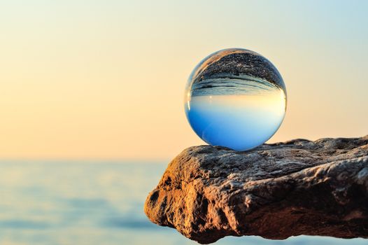 Glass bowl on the boulder at the sea