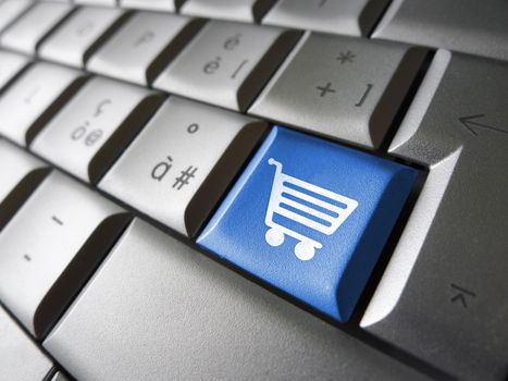 Online e-shopping concept with basket icon and symbol on a blue laptop computer key for Internet website and on line business.