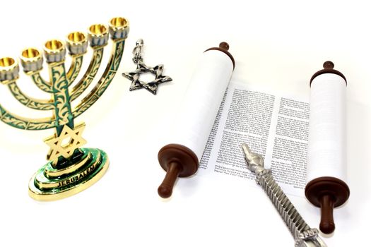 Torah scroll with menorah, Star of David and pointer on light background