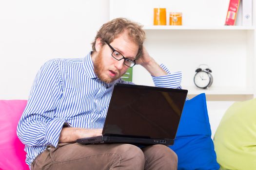 Fearful man looking at computer - studio shoot 