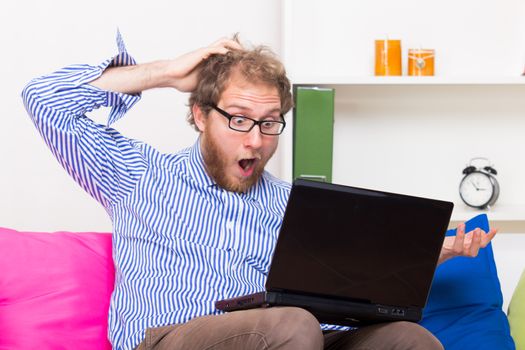 Fearful man looking at computer at room