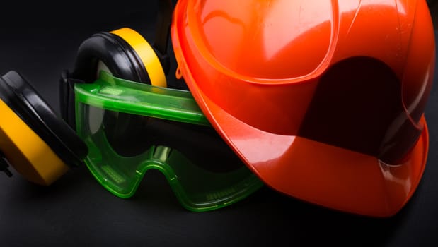 Red safety helmet with earphones and goggles