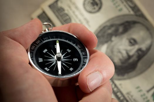 Hand holding silver black compass