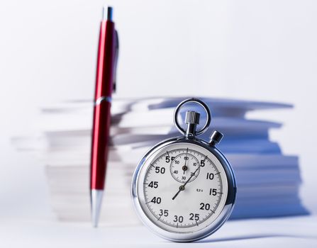 Stopwatch and pen on background of paper cards