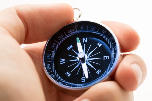 Hand holding silver black compass