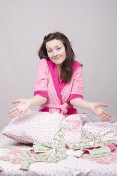 Girl sitting on the bed with a wad of bills for $ 50