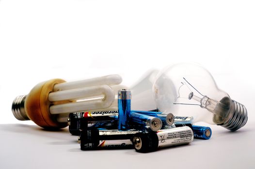 Recycling of used batteries and bulbs on white background