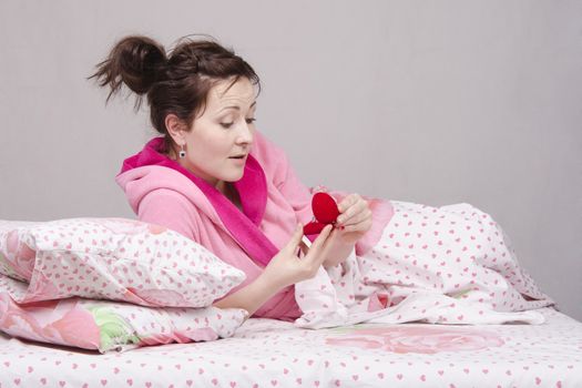 The girl lying in bed gave a ring in the case