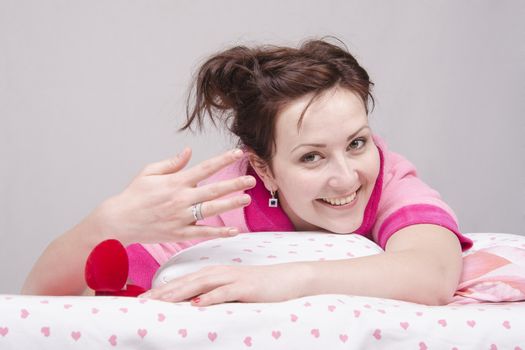 The girl gave a gift in the morning in bed, gave her a ring in the case.