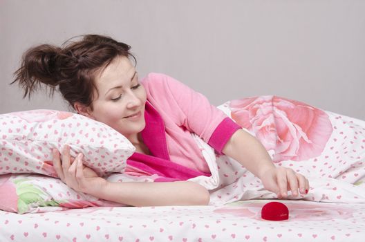 The girl lying in bed gave a ring in the case