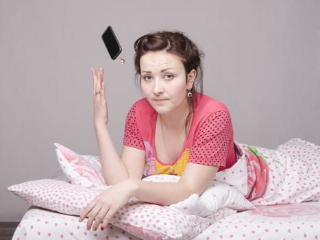 The girl lying in bed and talking on the phone