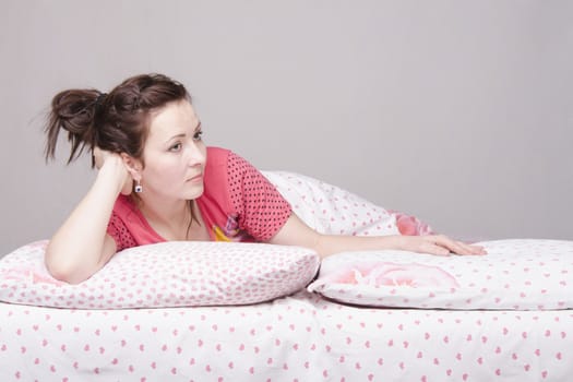 A young girl lying in bed one on one half