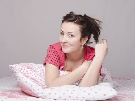 A young girl lying in bed with a smile and a dream